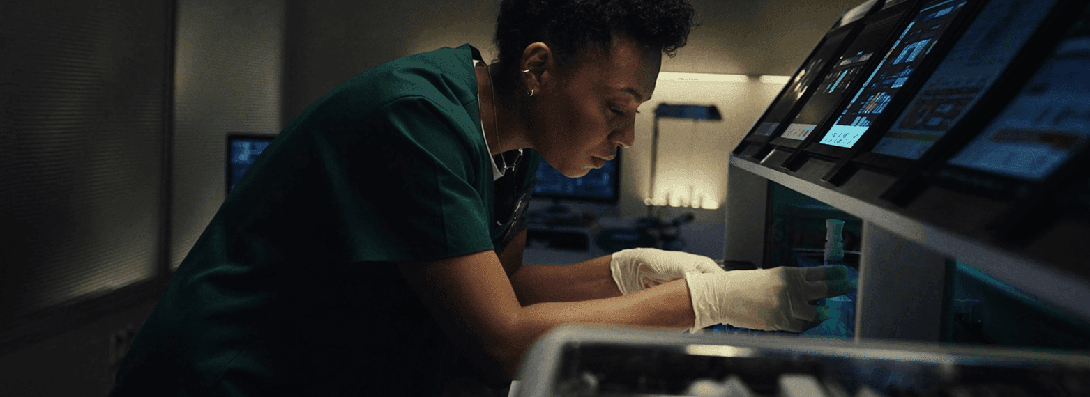 Scientist reviewing diagnostic work through a microscope